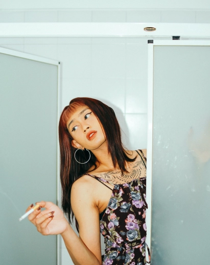 Portrait of an asian girl smoking in a bathroom